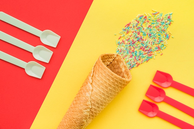 Бесплатное фото Цветной фон с ложками и конусом мороженого