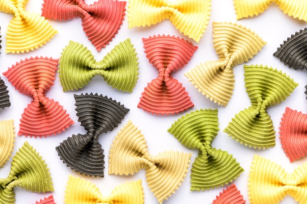 Colored bow tie pasta. closeup multiple farfalle isolated.