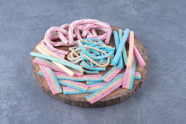 Colored candies in the form of a twisted rope on a board , on the marble.
