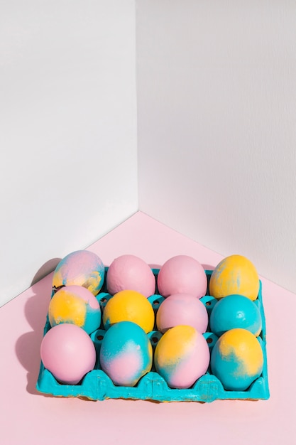 Цветные пасхальные яйца в большой яркой стойке на столе