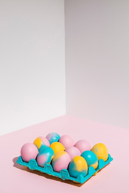 Colored Easter eggs in big rack on pink table