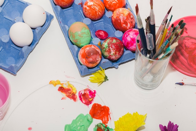 Colored eggs near brushes and palette