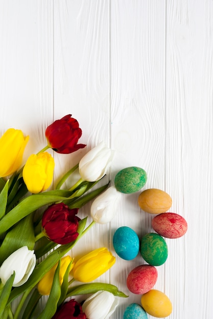 Colored eggs near tulips