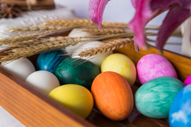 Colored eggs and wheat ears on tray