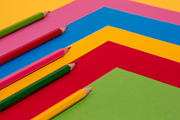 Цветные карандаши и листы цветной бумаги