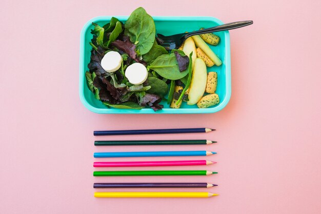 Цветные карандаши возле вкусного салата