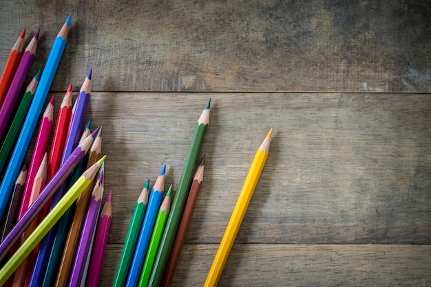 Colored pencils and note book on a wooden