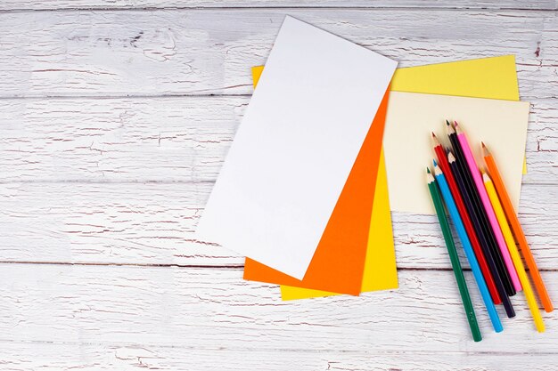 Цветные карандаши и бумага стоят на столе