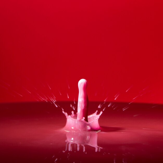 Colored pink droplet in red water