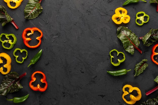 Цветные овощи свежие спелые и нарезанные на темный стол