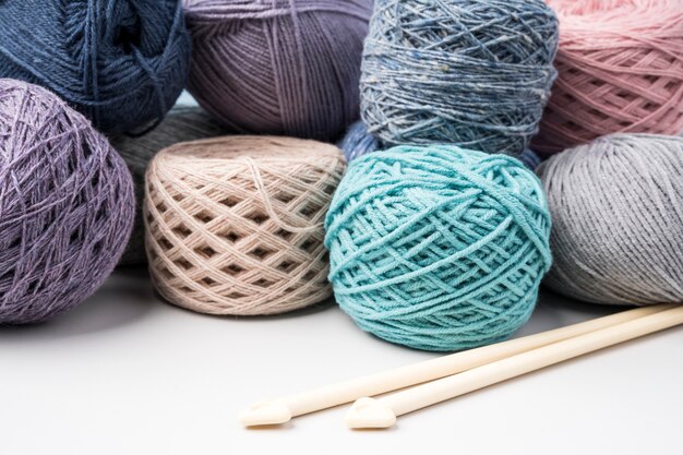 Colored wool yarn balls on white table