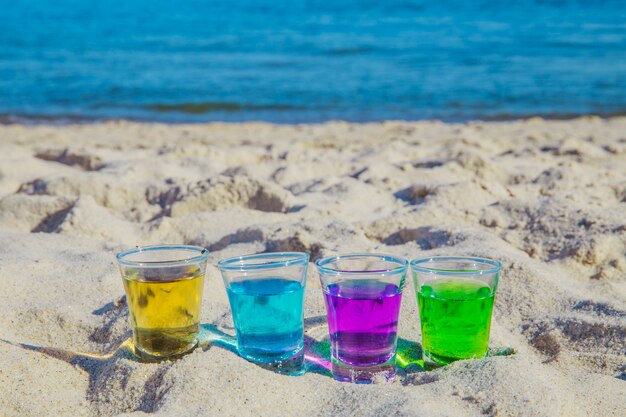 Colorful alcoholic shots on sand