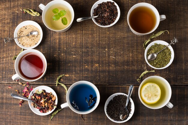 Colorful aroma tea cups arranged in circular position on wooden desk