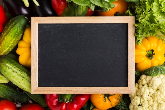 Colorful background with vegetables and blackboard