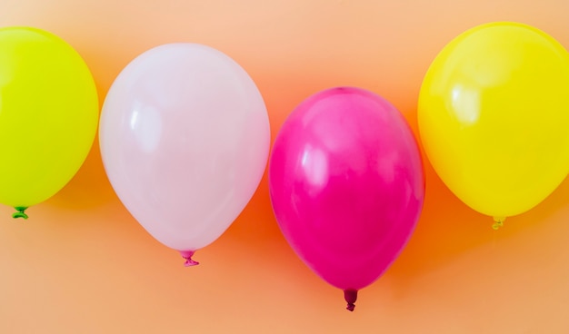 Colorful balloons on orange background