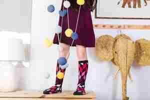 Free photo colorful balls and hearts hanging on string in front of girl standing over tabletop