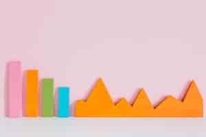 Free photo colorful bar graph and an orange graph on pink background