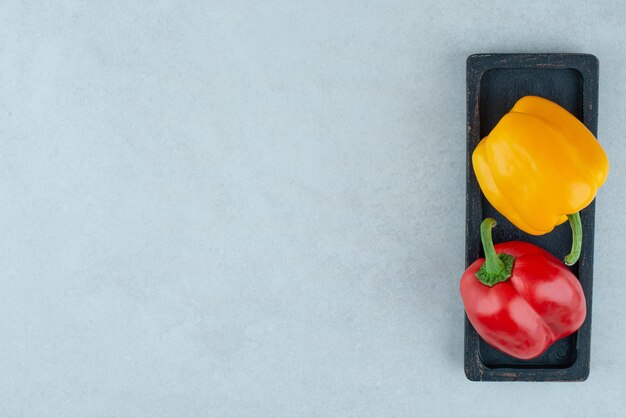 Colorful bell peppers on black plate.