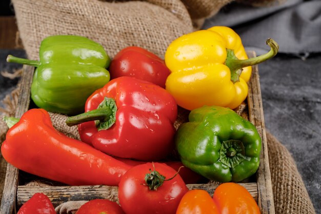Colorful bell peppers in a rustic tray. Top view.