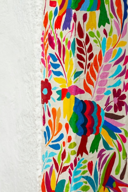 Colorful bird and leaves on white wall