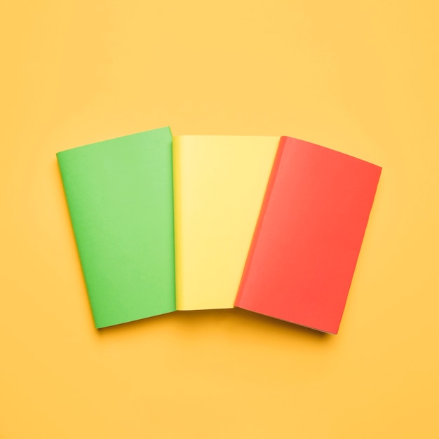 Free photo colorful blank books on yellow background