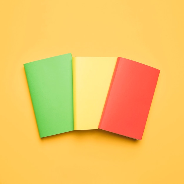 Colorful blank books on yellow background 