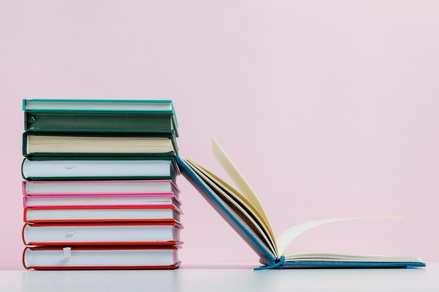 Colorful books with pink background arrangement