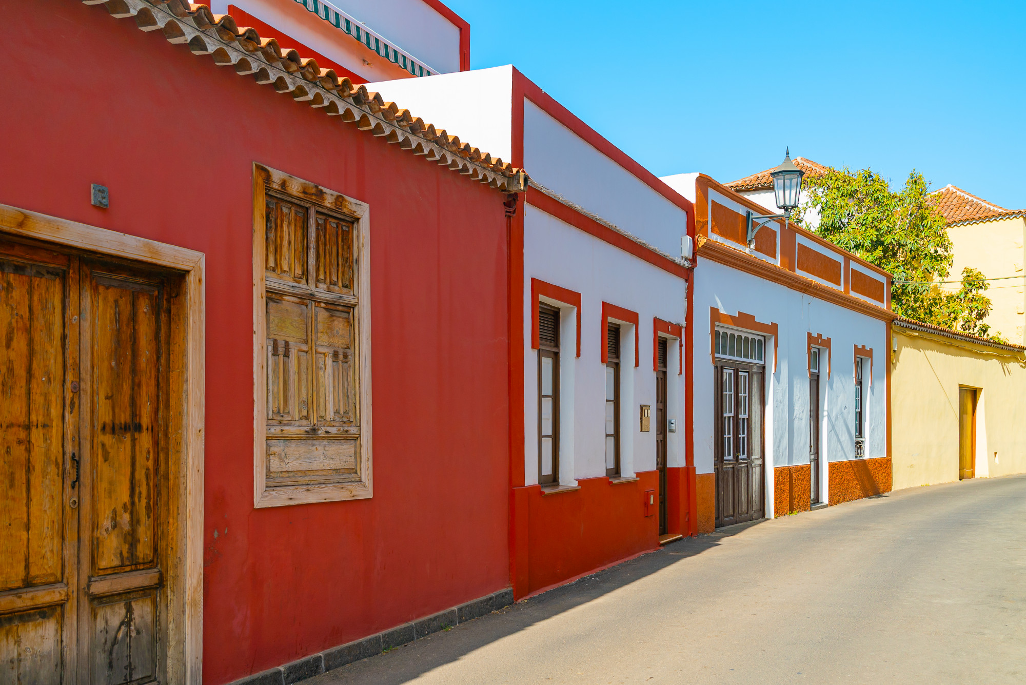 晴れた日、テネリフェ島、カナリア諸島、スペインのスペインの町ガラチコの狭い通りにカラフルな建物