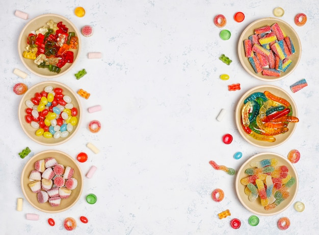 Colorful candies, jelly,marshmallow on light surface. Top view with copy space