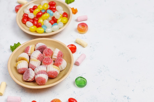 Caramelle colorate, gelatina, marshmallow sulla superficie della luce. vista dall'alto con spazio di copia