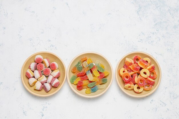 Colorful candies, jelly,marshmallow on light surface. Top view with copy space