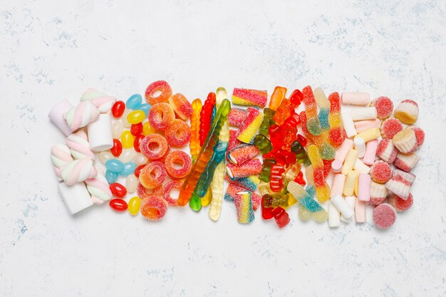 Colorful candies, jelly,marshmallow on light surface. Top view with copy space