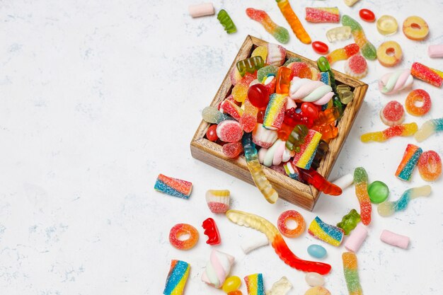 Colorful candies, jelly,marshmallow on light surface. Top view with copy space