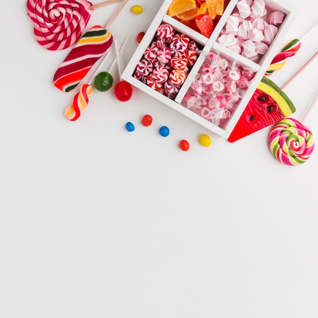 Colorful candies on white table with copy space