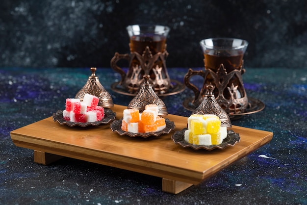 Free photo colorful candies with fragrant tea on blue surface