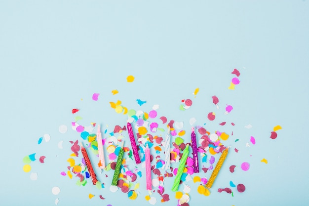 Colorful candles with confetti on blue background