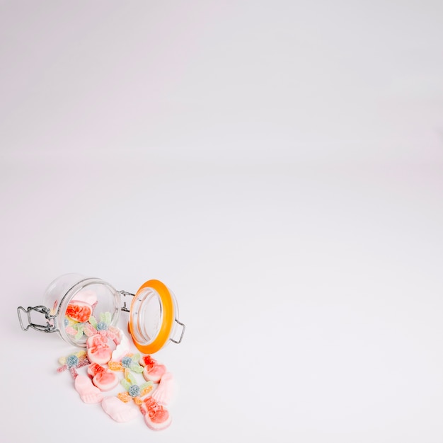 Colorful candy falling out of glass jar