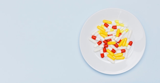 Colorful capsules on plate copy space