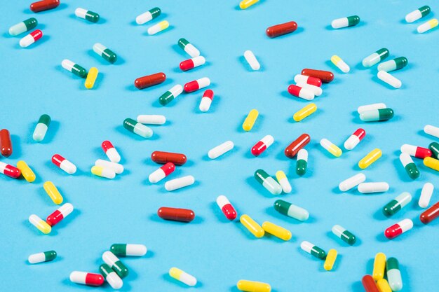 Colorful capsules spread on blue background