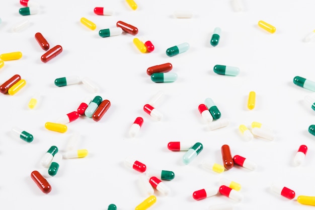 Colorful capsules spread on white background