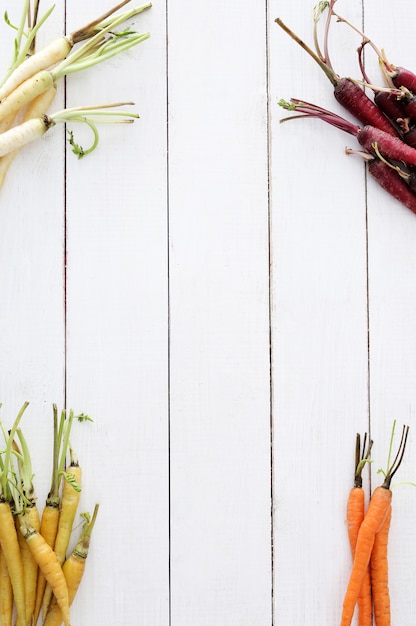 Colorful carrots on wooden table background