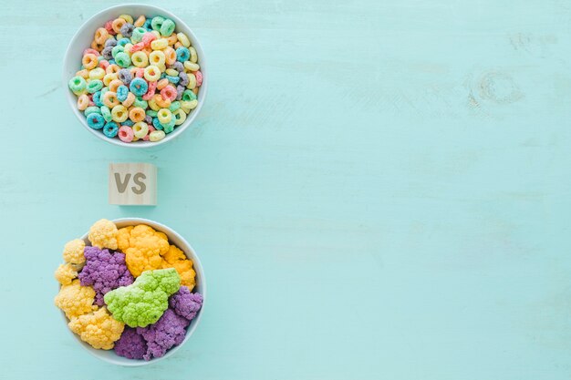 Colorful cauliflower versus cereals in bowls over blue backdrop