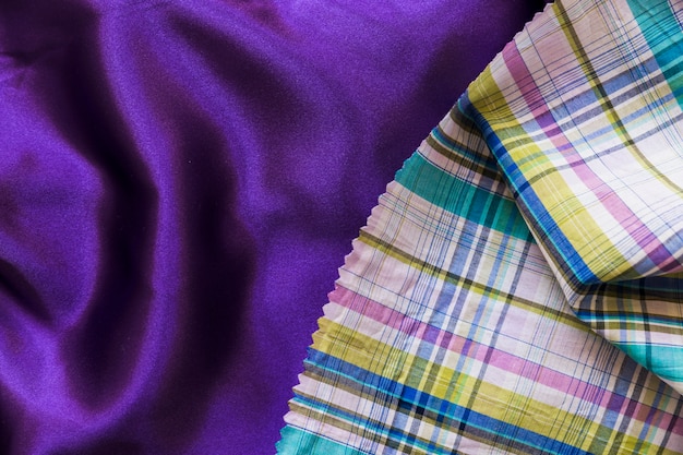 Colorful chequered pattern cloth on plain purple textile