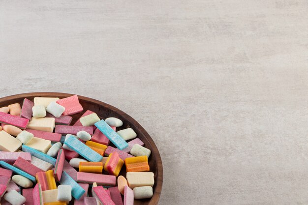 Colorful chewing gums placed on a stone table .