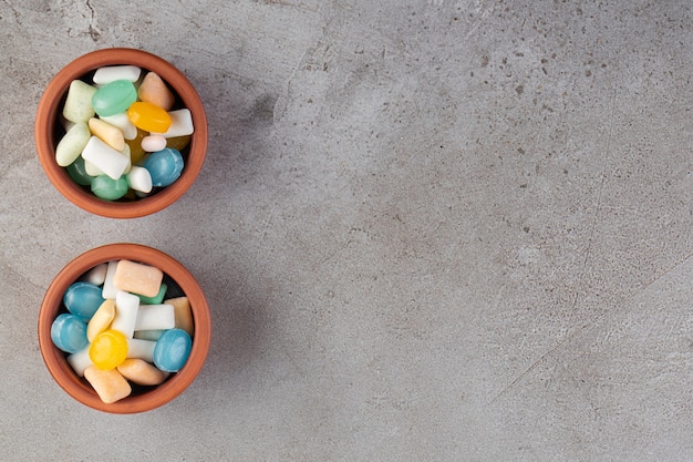 Colorful chewing gums placed on a stone table .