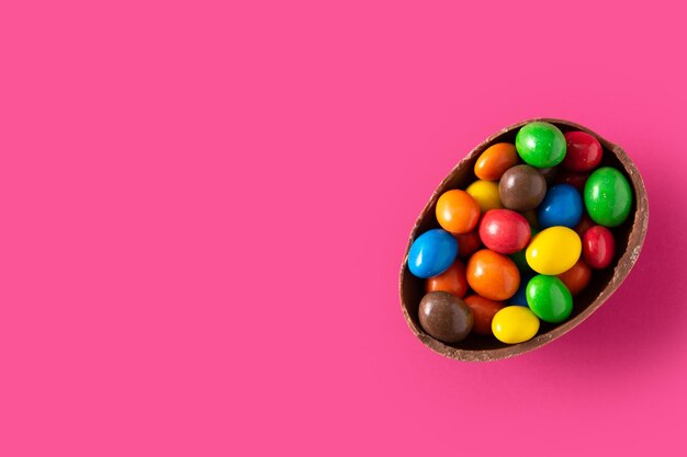 Colorful chocolate Easter eggs on pink background