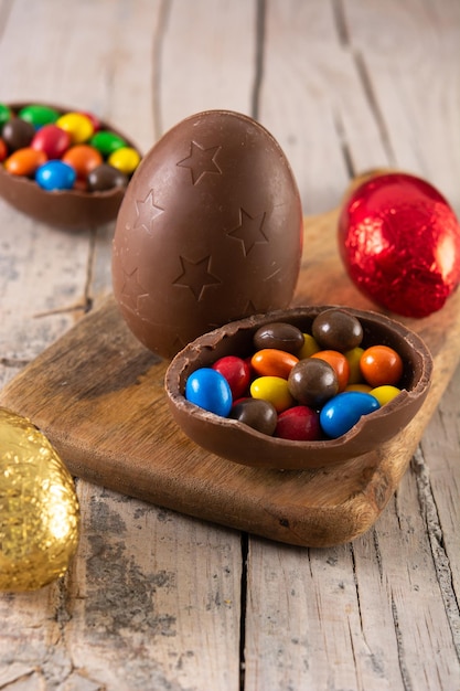 Foto gratuita uova di pasqua di cioccolato colorate sulla tavola di legno