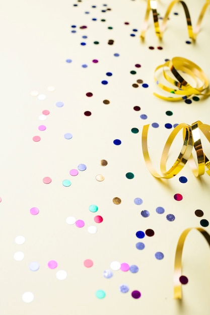 Free photo colorful confetti and golden ribbons