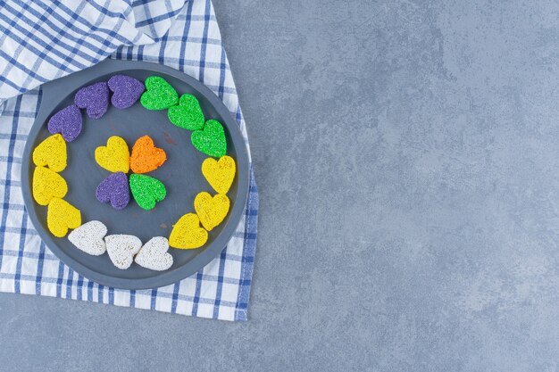 Colorful cookies in the board on the towel, on the marble surface
