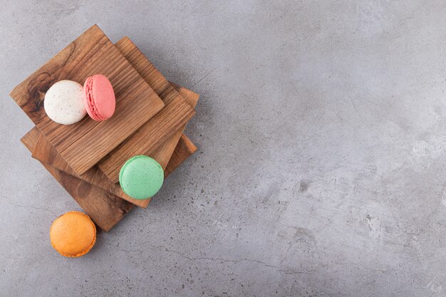 Colorful cookies on wooden board on grey surface